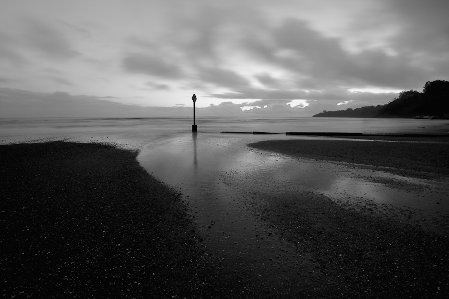 Where the water enters Bolinas Bay, at night.  I do not know why I made this photo light and grey when the actual experience was purple and dark.  Look closely and you will see a surfer surfing well after sunset.