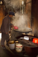 cooking spinach soup on a coal fire for the pigs