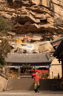 Wild Monkeys have the run of Baoxiang temple (宝相寺) which was built at the end of the 13th century, when Yunnan was formally integrated in the Chinese Empire, after the Mongols invaded the country and much of Asia and founded in China the short-lived Yuan dynasty (1271-1368).<br />Guanyin and Maitreya, the smiling Buddha, are visible from the main gate.  They on a passage which links two overhanging temples part way up an overhanging cliff over the main temples below.
