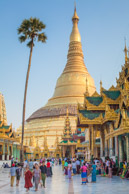 Shwedagon Pagoda with a 2600 year history stands 326 feet tall above Sanguttara hill in Rangoon to enshrine 8 hairs of the Gautama Buddha.   For some idea of scale: to reflect the sun the golden orb at the top is ten inches wide, has a 76 carat diamond at the top and total of 4351 diamonds which are 1800 carats.   Below the orb the weather vane is 4 feet wide and including a half ton of gold and jewels.   Below the vane, the umbrella is 13 meters tall and made of another half ton of gold and 83,850 jewels weighing a total of 5 tons.   The upper half of the pagoda is covered in gold plates and the lower half in gold leaves.  (5d)